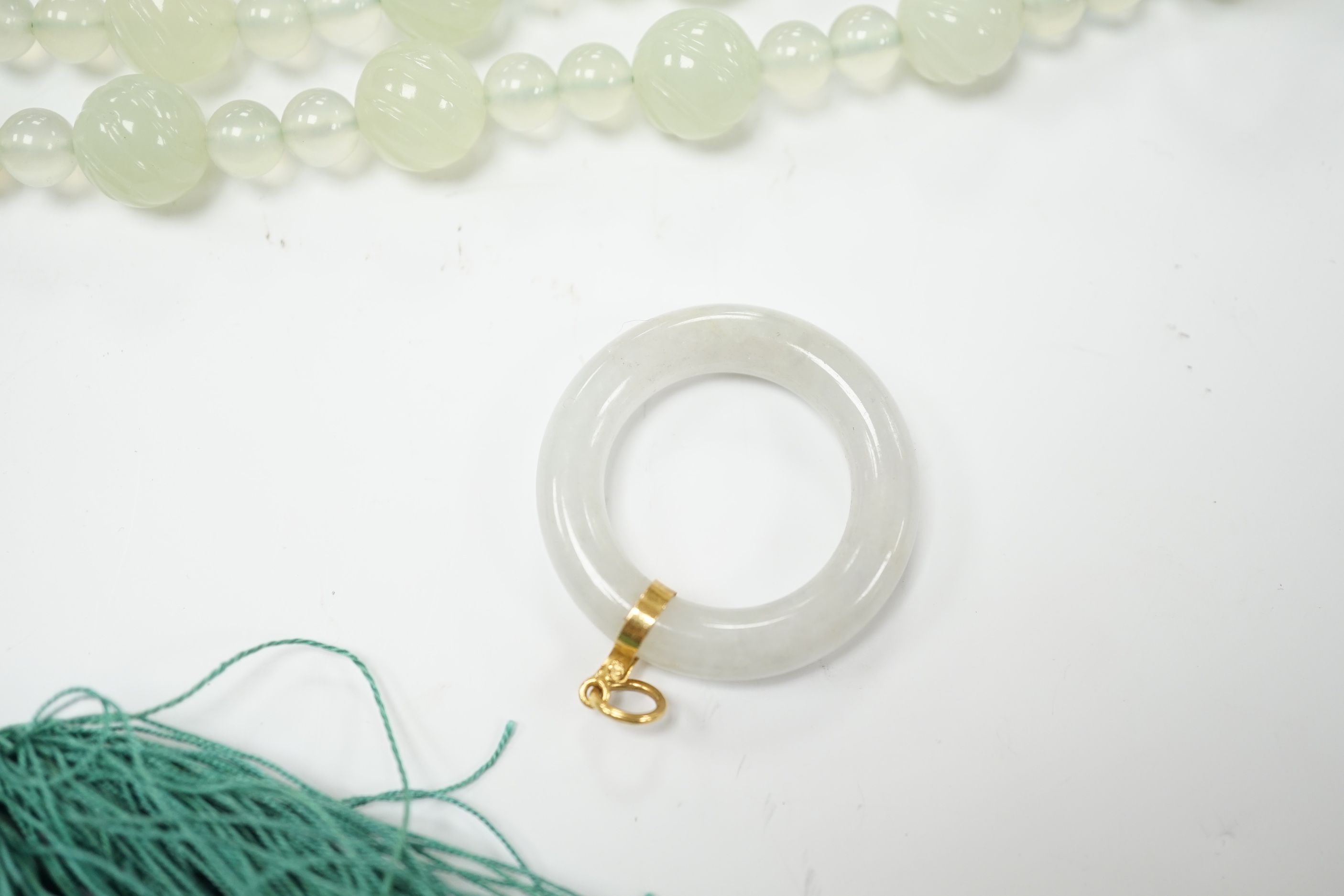 A bowenite jade bead necklace with dragon head clasp, circular pendant and carved disc